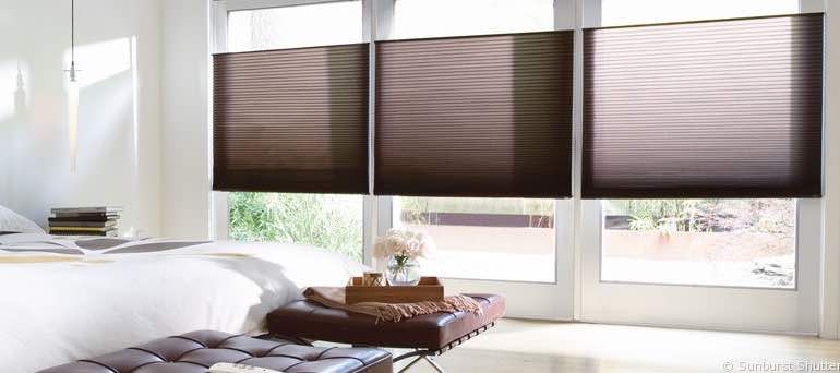 Modern Austin bedroom with high ceiling windows and brown honeycomb shades.