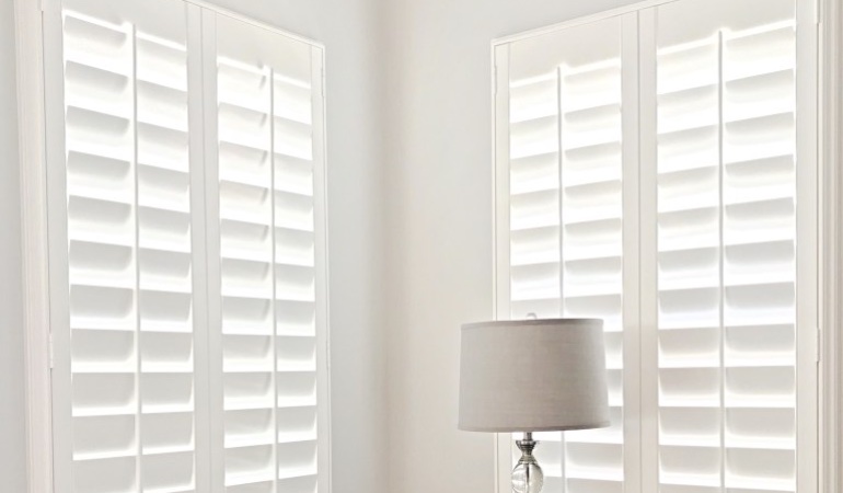 Plantation shutters are available in a variety of neutral whites and wood stains. Plantation shutters in a corner window.