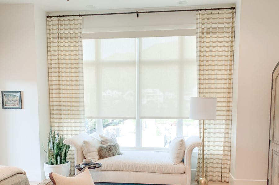 Never struggle with large or hard-to-reach window treatments again when you put a motorized shade on your window. White motorized shades on a large bedroom window