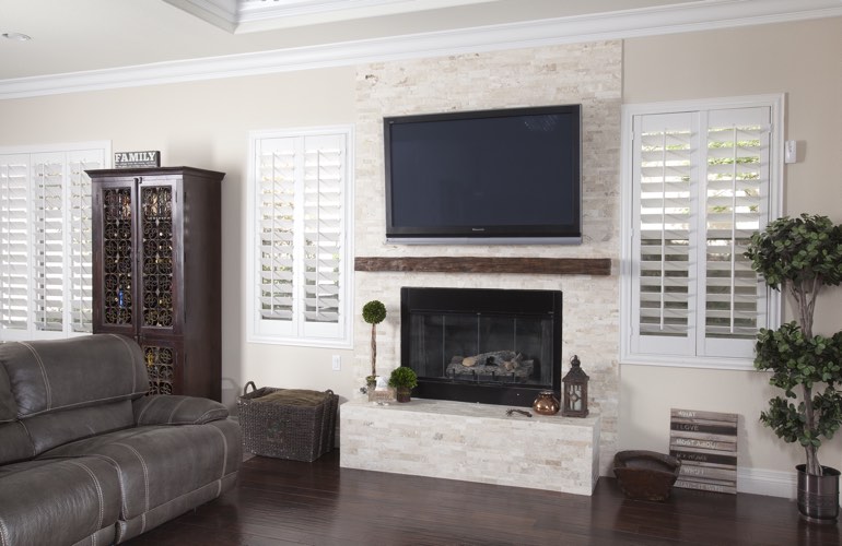 White plantation shutters in a Austin living room with solid hardwood floors. White plantation shutters in a Austin living room with solid hardwood floors.