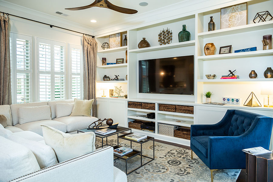 White Polywood shutters, walls, and furniture make for a pleasantly light and airy guest house. White Polywood shutters on windows in a large living space with built-in shelves.