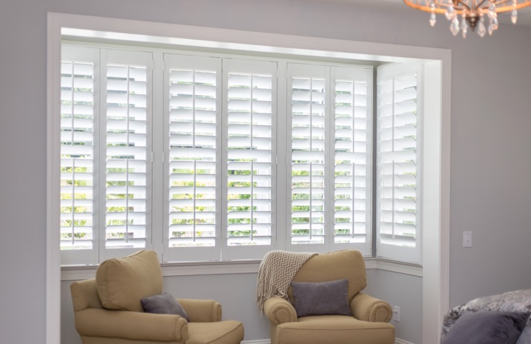 North-South windows can have energy efficiency problems rather than sun glare problems. White plantation shutters in sitting area