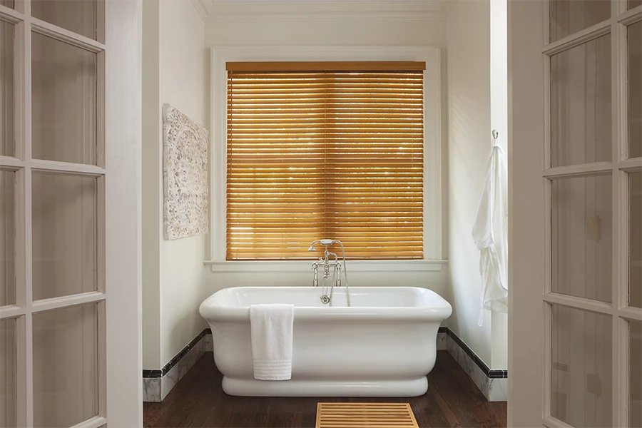 Brown faux-wood blinds on a bathroom window