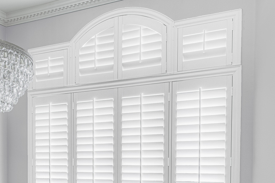Customize your Palladian windows with white Polywood shutters in Austin. White Polywood Palladian windows in a dining room.