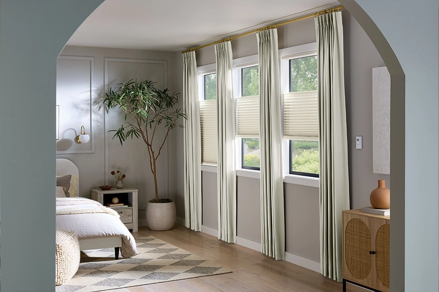 Keep your remote control beside your bed for easy motorized shade operation. White motorized shades on bedroom windows