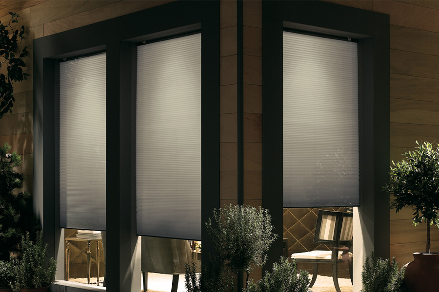 Cellular shades are modern and stylish window treatments for your home in Austin. Dark gray cellular shades displayed from the exterior of a home.